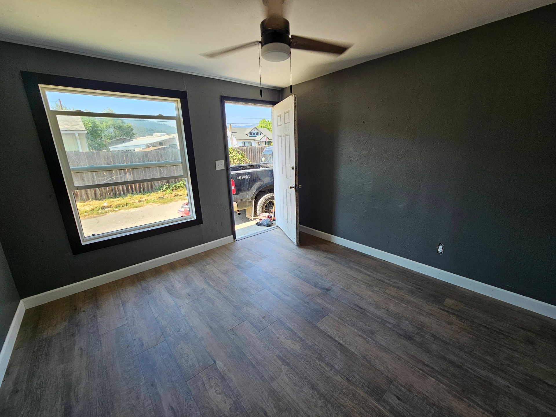 Bedroom with bold dark accent paint and new vinyl plank floors