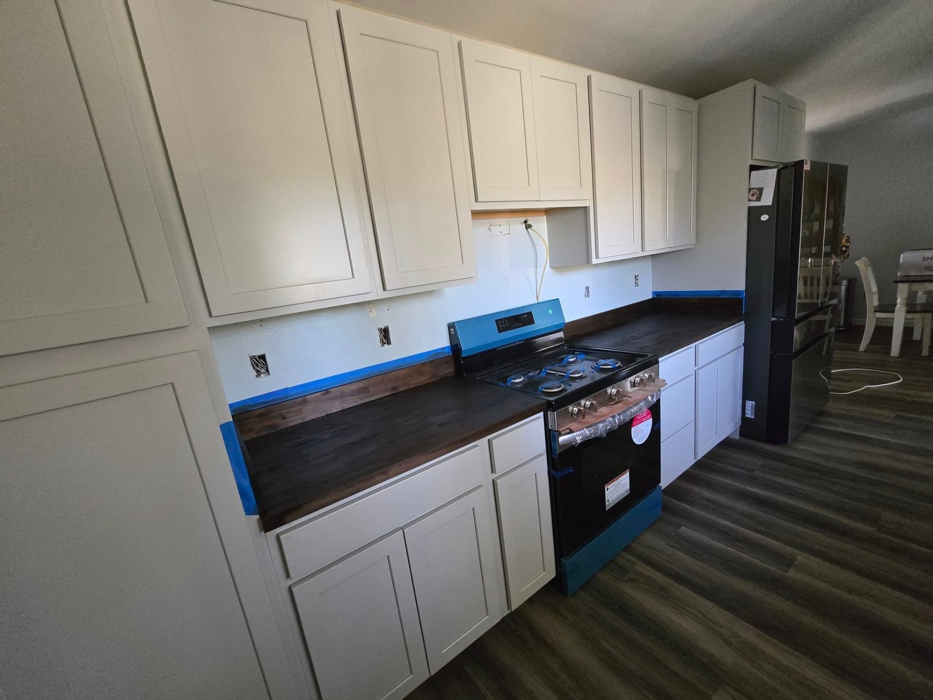 Freshly installed white shaker cabinets with butcher block counters