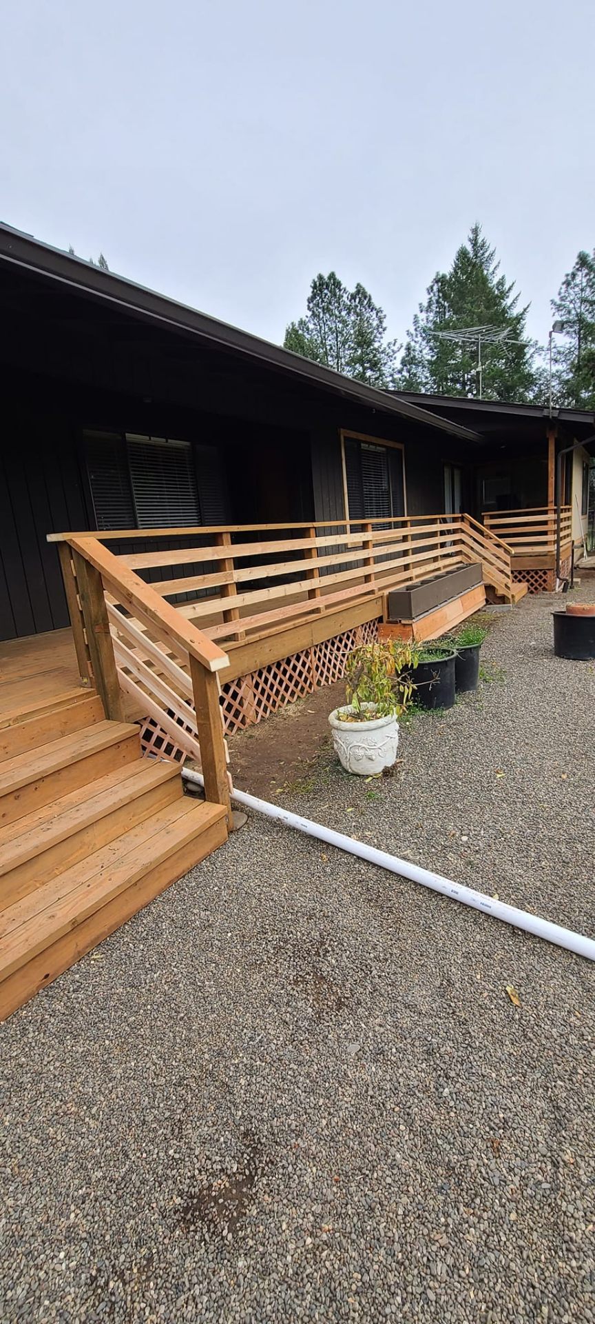 Cedar deck with ADA-friendly ramp and railings wrapping a country home