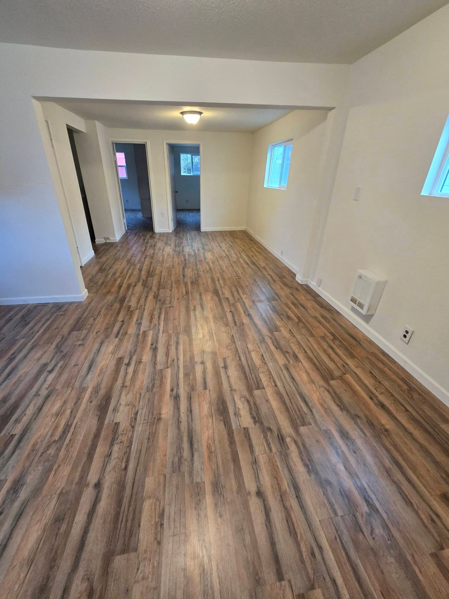Open living area with freshly installed rustic vinyl plank flooring