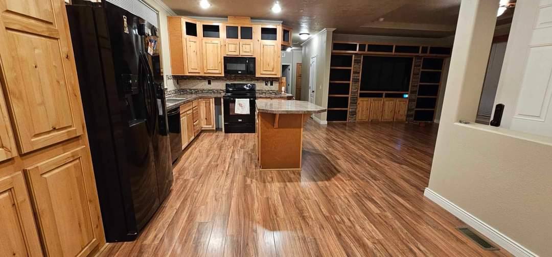 Completed open-concept kitchen with knotty alder cabinets and built-ins
