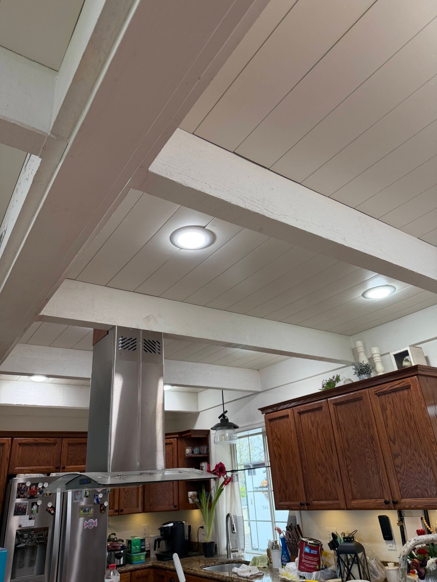 Kitchen with refinished natural wood ceiling beams and updated lighting