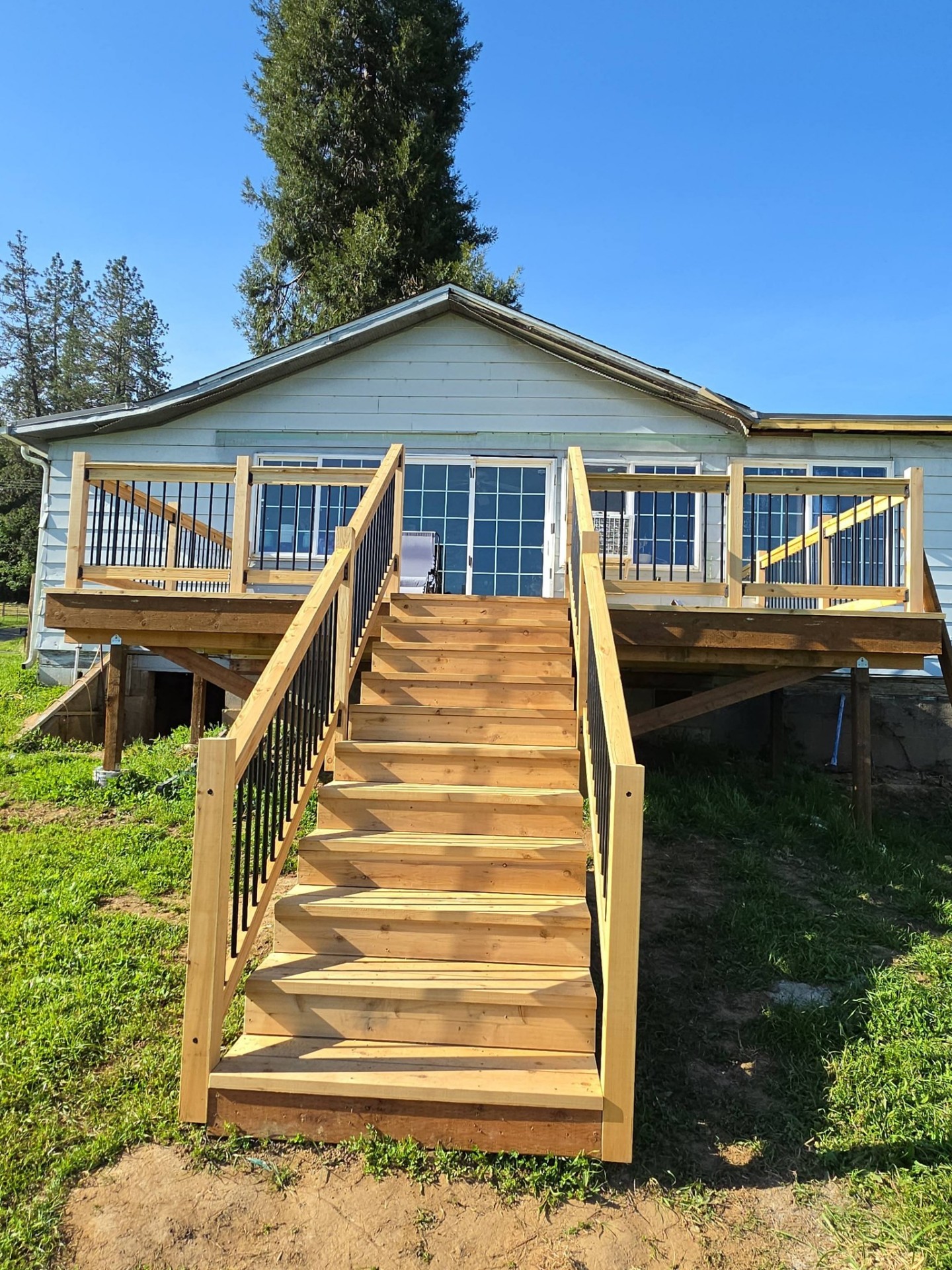 Completed custom cedar deck with wide staircase and metal baluster railings